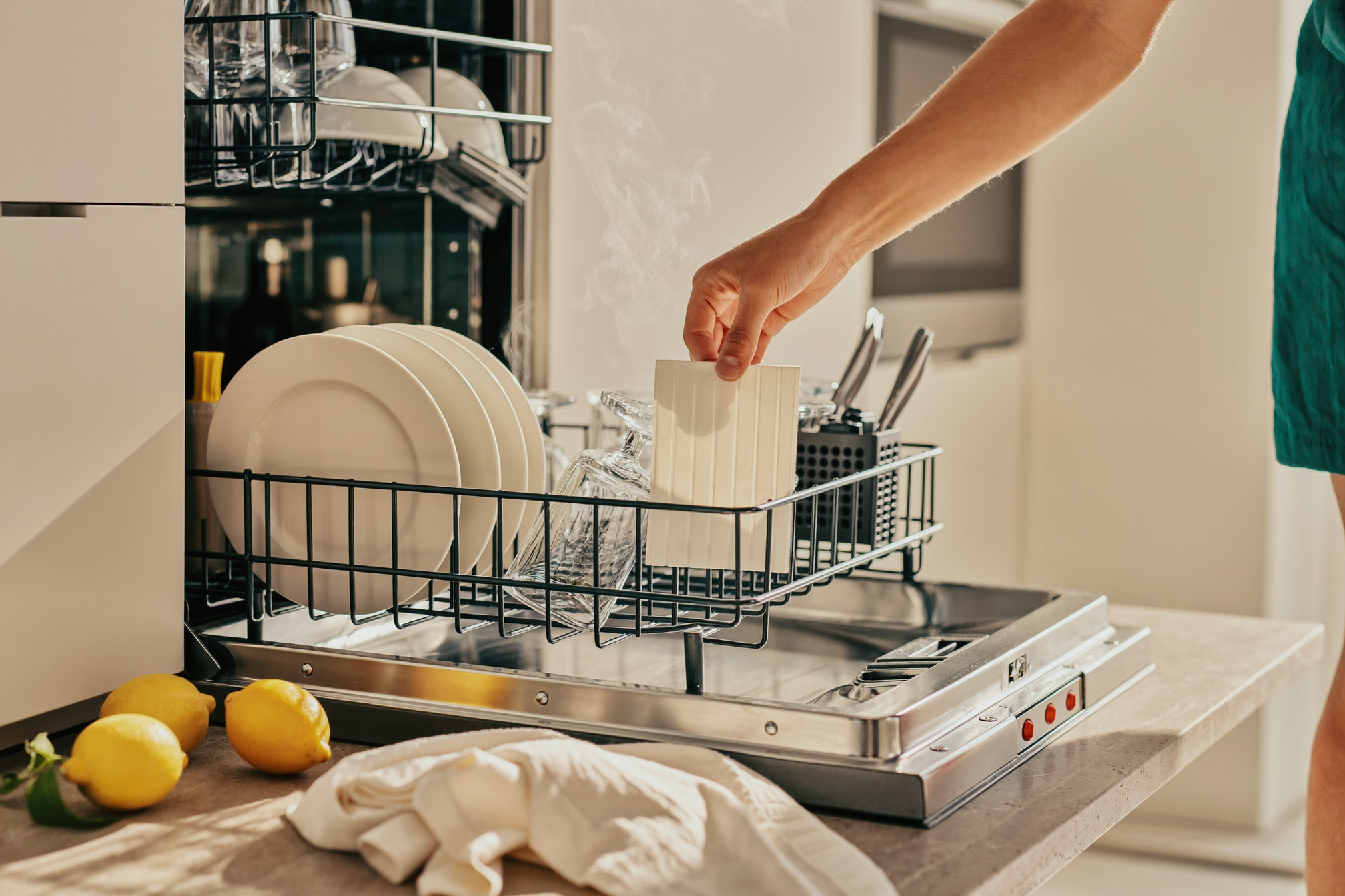 Placing a Dissolv dishwasher detergent sheet into a dishwasher full of sparkling clean dishes